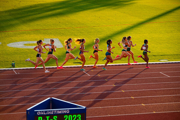 B. BYSTRICA, SLOVAKIA, JULY 20, 2023: Elegance in Motion: Female Athletes Excel in 800m Run under Picturesque Sunset Light at Track and Field Venue for Worlds in Budapest and Summer olympic in Paris