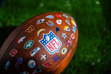 NEW YORK, ABD, 11 Eylül 2023: NFL futbol topu, milli futbol ligi logosu ve tüm takımların logosu. Yeşil arkaplan, boşluğu düzenle