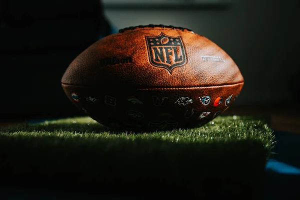 stock image NEW YORK, USA, SEPTEMBER 11, 2023: NFL's Trademark: Leather Ball and Iconic Logo. Official National Football league ball places in shadow of athletes dressing room. Black edit space