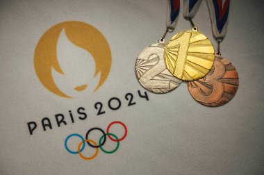 PARIS, FRANCE, 4 HAZİRAN. 2024: Beyaz battaniyede altın ve bronz madalya ve Paris 2024 Yaz Olimpiyatları 'nın resmi logosu