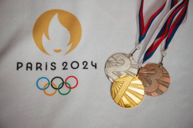 PARIS, FRANCE, JANUARY 4. 2024: Paris 2024 Summer Games Memorabilia: White Blanket Presentation of Gold, Silver, and Bronze Medals with Official Logo clipart