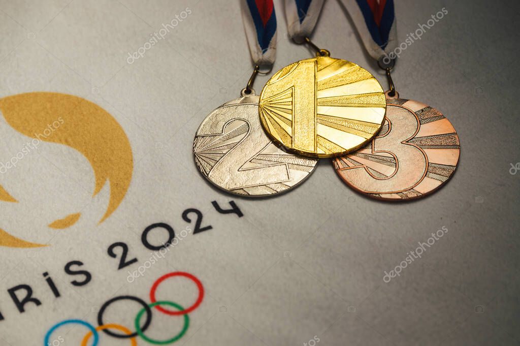 PARIS, FRANCE, JANUARY 4. 2024: Exclusive Display: Official Paris 2024 Summer Olympics Logo on White Blanket with Gold, Silver, and Bronze Medals