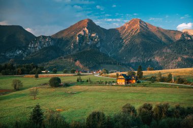 Sabah vakti yüksek dağların altında ahşap bir kulübe. Zdiar, Slovakya, High Tatras