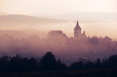 Kırsal Kilise silueti sonbaharda sakin sabah sisinde