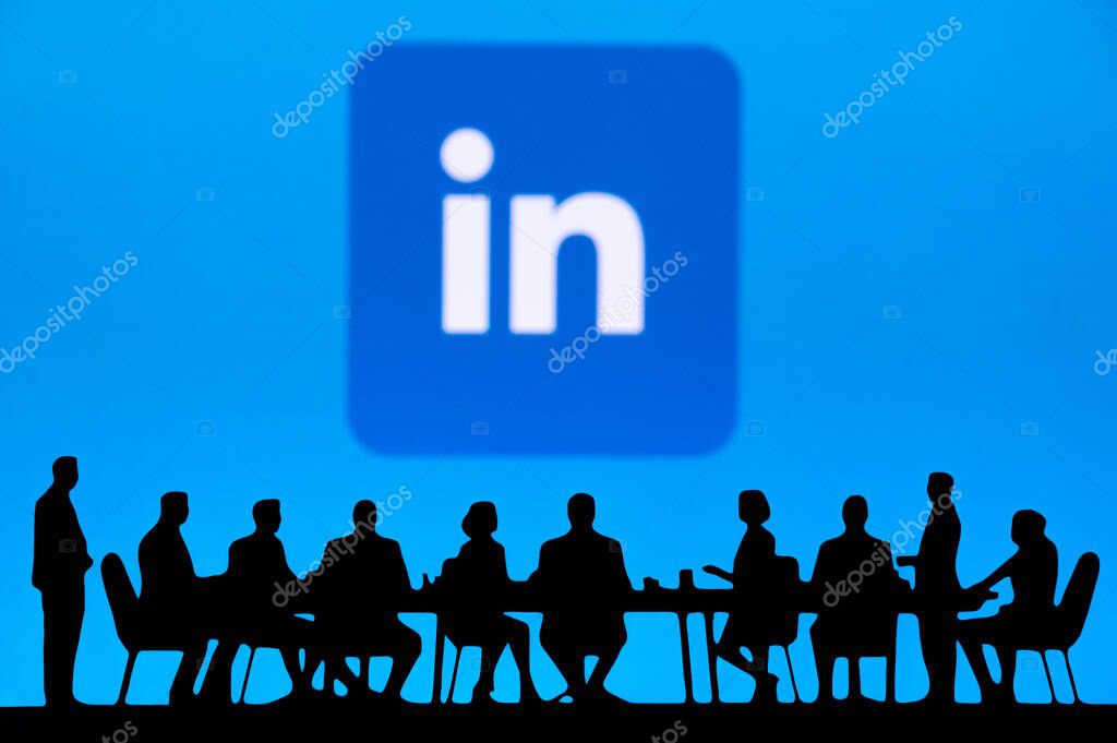 SUNNYVALE, USA, OCTOBER 10, 2024: LinkedIn Corporate Growth Summit. Silhouettes of senior management brainstorming around a conference table, financial graphs on a big screen in the background.