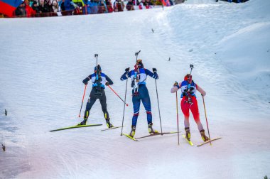 Üç Biatlet Karlı Sahada Aksiyon 'da. Kadın Biatletler Profesyonel Yarış 'ta yarışıyor. İskandinav kayak sporu fotoğrafı
