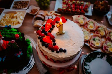 A delightful first birthday cake with a number '1' surrounded by fresh berries, creating a joyful and memorable moment for a child's special day clipart