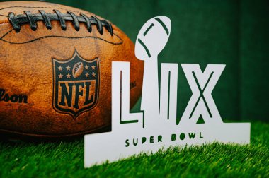 YENİ ORLEANS, ABD, 27 HAZİRAN 2025: LIX Super Bowl. Kansas City Chiefs ve Philadelphia Eagles arasında 2024 sezonluk NFL finallerinin kağıt kesimi beyaz logosu. Yeşil çimlerde Amerikan Futbolu