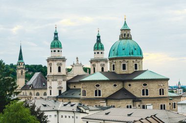 Avusturya 'da Salzburg. Bir binanın tepesinde büyük yeşil bir kubbe oturuyor. Bina diğer binalarla çevrilidir. Gökyüzü bulutlu.