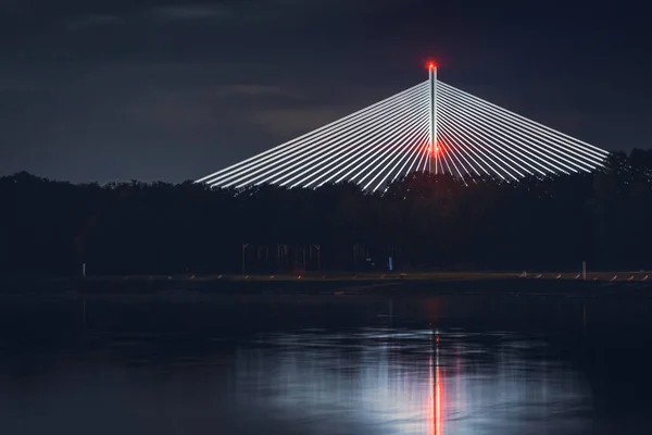 夜にライトアップされたRedzinski Bridgeは Odra川のほとりの木々の上に高くそびえています — ストック写真