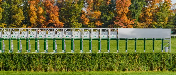Wroclaw, horse racing track, starting gates for horses, autumn landscape with colorful trees on a sunny day.