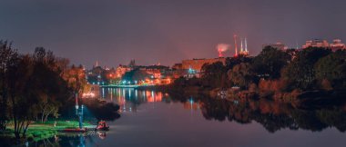 Wroclaw, su kurtarma servisi, Odra nehrinin kıyısına demir atmış bir tekne. Nehirdeki gece manzarası.