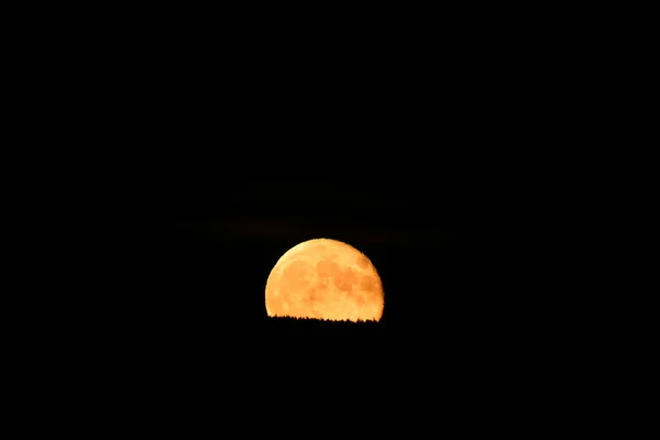 사냥꾼 보름달이 오렌지 달빛이 보이는 크레이터와 위에서 모습을 드러낸다 — 스톡 사진