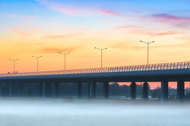 Akşamın ilerleyen saatlerinde Odra nehrinin üzerindeki Redzinski köprüsünü kırın. Nehrin üzerinde yoğun bir sis var serin bir akşamda, otoyolda.