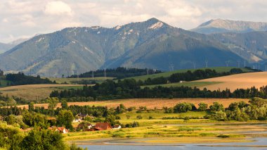 Besenova köyünden dağ manzarası, alçak Tatras Ulusal Parkı 'ndaki yüksek dağ zirveleri manzarası. Vah nehri kıyısındaki yapay su deposunun manzarası.