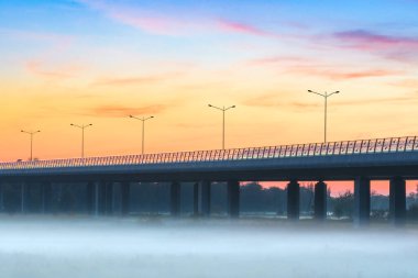 Akşamın ilerleyen saatlerinde Odra nehrinin üzerindeki Redzinski köprüsünü kırın. Nehrin üzerinde yoğun bir sis var serin bir akşamda, otoyolda.