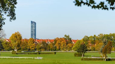 Yılan pençesi, engelli at yarışı pisti güneşli bir günde ağaçlarla dolu sonbahar manzarası. Uzaktaki modern Gökyüzü Kulesi..