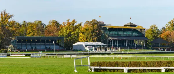 Wroclaw, engelli at yarışı pisti ve taraftarlar için yüksek tribünler, güneşli bir günde renkli ağaçlı sonbahar manzarası.