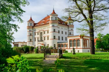 Wojanow Sarayı, İngiliz neo-gotik tarzında etkileyici bir bina. Tesis Bobr Nehri kıyısında, bahçelerle çevrili, güneşli bir yaz gününde yürüyüş alanından dikiz manzaralı.