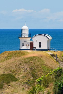 Macquarie Limanı Deniz feneri, uçurumun tepesinde beyaz deniz feneri güneşli bir yaz gününde deniz manzarası.