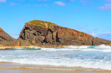 Queens Head Gözcüsü, Avustralya sahil şeridi, deniz kenarında kayalar, kumlu sahilden güneşli bir yaz akşamında deniz manzarası.