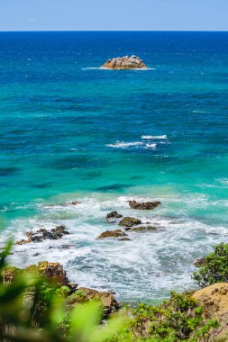 Avustralya kıyıları, kıyılarda kayalar olan mavi deniz, güneşli bir yaz gününde deniz kenarındaki kayalıklardan manzara.