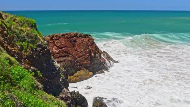オーストラリアの海岸は 晴れた日には岩の海岸で崖から青い海まで見えます 海の風景 海岸の火山岩に衝突する波 — ストック動画