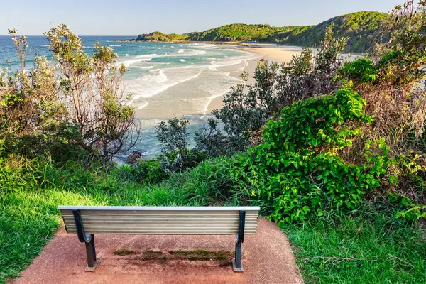 Avustralya sahiline bakan bir uçurumun tepesinde kumlu bir plajı olan bir bank. Güneşli bir yaz gününde uçurumdan manzara.