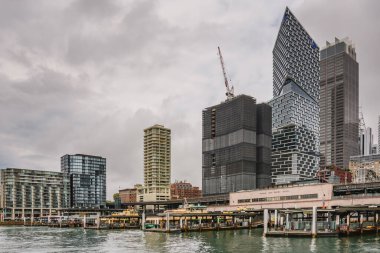 Sydney, Avustralya - 3 Mart 2023: Circular Quay, yüksek gökdelenleri ve şehir mimarisi olan feribot iskelesi.