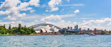 Sydney, Avustralya - 04 Mart 2023: Royal Botanic Garden Sydney, Sydney Opera Binası ve Sydney Harbor Köprüsü nehir kenarındaki parkta yaz güneşli bir günde.