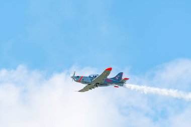 Leszno, Polonya - 22 Haziran 2024: Antidotum Airshow Leszno, PZL-130 Orlik, pervane eğitim uçağı. Pilot havada akrobasi yapıyor, arkasında muhteşem bir duman bırakıyor..