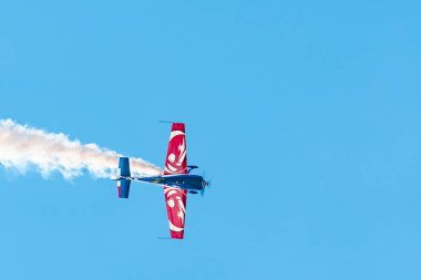 Leszno, Polonya - 22 Haziran 2024: Extra 330 uçağıyla Antidotum Airshow Leszno, Florent Oddon. Pilot havada akrobasi yapıyor, arkasında muhteşem bir duman bırakıyor..