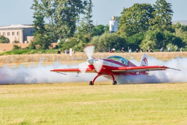 Leszno, Polonya - 22 Haziran 2024: Antidotum Airshow Leszno, Zelazny Aerobatic Team, Zlin 50. Pilot havaalanından havalanıyor ve uçağın arkasından muhteşem bir duman yayıyor..