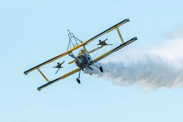 stock image Leszno, Poland - June, 22, 2024: Antidotum Airshow Leszno, Scandinavian Airshow Catwalk, Grumman G-164A Ag-Cat. Acrobats perform a show on wings of a flying plane, spectacular smoke behind the plane.