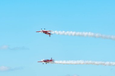 Leszno, Poland - June, 22, 2024: Antidotum Airshow Leszno, Zelazny Aerobatic Team, Zlin 50. Pilots perform acrobatics in the sky, they leave spectacular smoke behind the plane. clipart