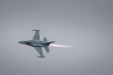 Leszno, Poland - June, 22, 2024: Antidotum Airshow Leszno, F-16 Tiger Demo Team, F-16C Block 52+ plane.Night show, fighter pilot performs maneuvers, visible flames from the jet engine behind the plane clipart