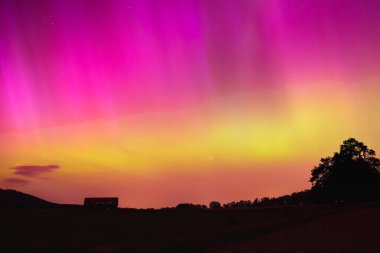 Polonya 'da Aurora Borealis, gece gökyüzünde renkli bir gösteri, dağ manzarasında bir ışık fenomeni.