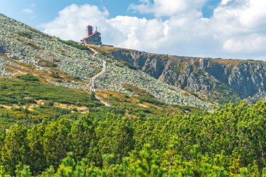 Karkonosze Dağları, Batı Sudetleri, Sniezne Kotly ve bayrak istasyonu manzaralı dağ manzarası, güneşli bir yaz gününde yeşil alp bitkileriyle kayalık yol..