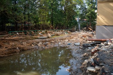 Ladek Zdroj, Poland - September, 17, 2024: Destroyed yard of a residential building by a rushing river, two days after the flood wave passed through the city. View from Kosciuszki Street. clipart