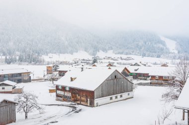 Avusturya, Schoppernau 14 Şubat 2025 - Alpler kış manzarası, dağ vadisindeki küçük bir kasaba, karla kaplı evler, karlı bir gün.