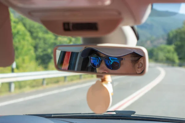 Közelkép Egy Napszemüveges Nőről Aki Egy Autó Visszapillantó Tükrében Tükröződik — Stock Fotó