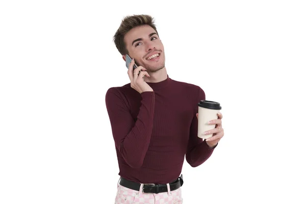 白い背景の上に隔離されたコーヒーカップで電話で話す若い白人男性の笑顔 — ストック写真