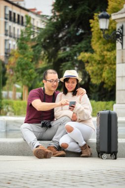 Çok ırklı iki turist akıllı telefonlarıyla şehir rehberine danışıyor. Madrid, İspanya 'yı gezmek.