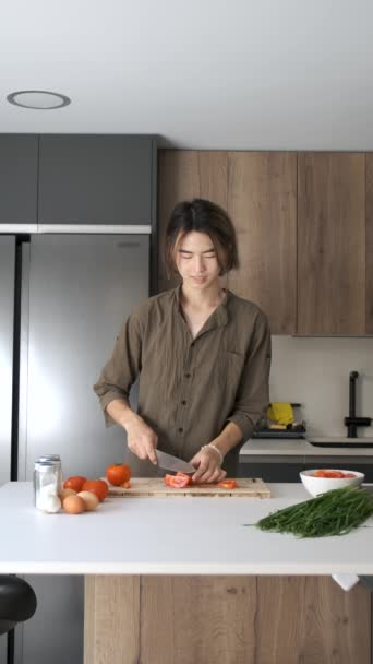 Glimlachende Aziatische Jongeman Snijden Tomaten Keuken — Stockvideo