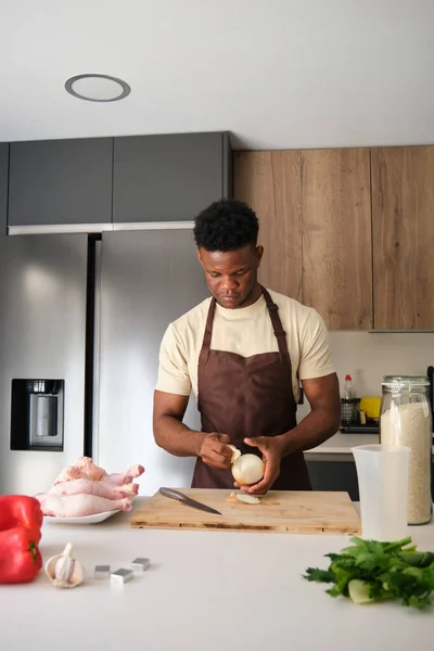 Young African Man Peeling Onion Prepare Chicken Recipe Kitchen — Stock Photo, Image