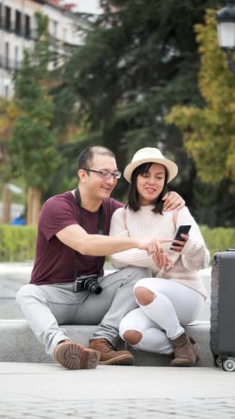 観光客の多人種カップルは 彼らのスマートフォンで都市ガイドをコンサルティング スペイン マドリード観光 — ストック動画