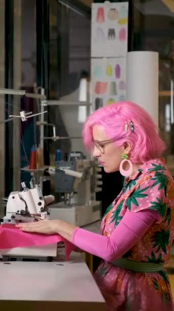 Krawcowa Różowymi Włosami Kolorowymi Ubraniami Pracująca Overlockerze Warsztacie Szycia — Wideo stockowe