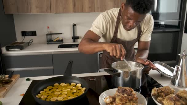 年轻的黑人男子试图用米饭检查它是否在厨房里烹调 — 图库视频影像