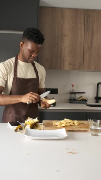 Junger Schwarzer Mann Schält Und Schneidet Kochbananen Einer Küche — Stockvideo