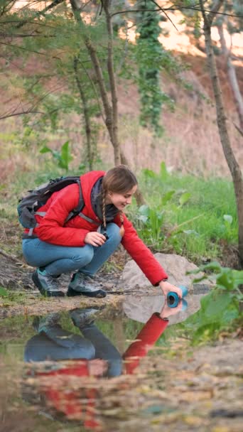 Junge Wanderin Füllt Wasserflasche Mit Rohwasser Fluss — Stockvideo